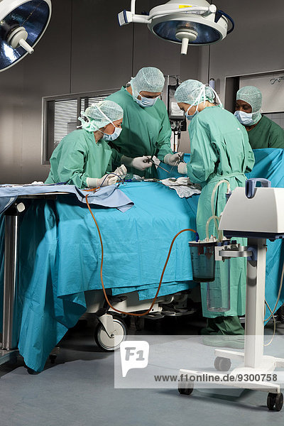 Ärzte und Krankenschwestern  die einen Patienten im Operationssaal operieren