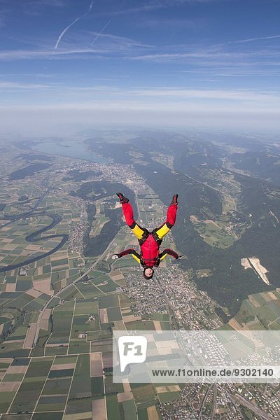 Female skydiver free falling upside down over Grenchen  Berne  Switzerland