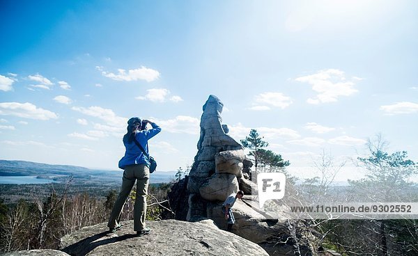 Zwei Wanderer auf einer Felsformation beim Fotografieren
