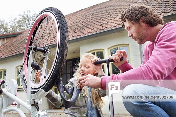 Vater und Tochter reparieren Fahrrad
