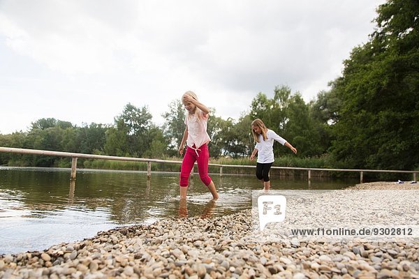 Zwei Mädchen paddeln im ländlichen See