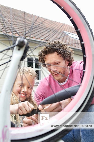 Vater und Tochter reparieren Fahrrad
