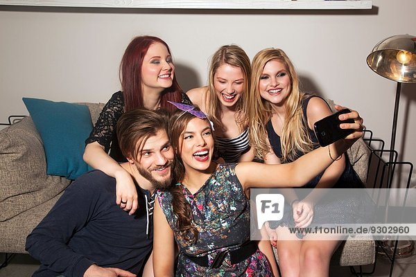 Freunde nehmen Selfie auf dem Sofa.