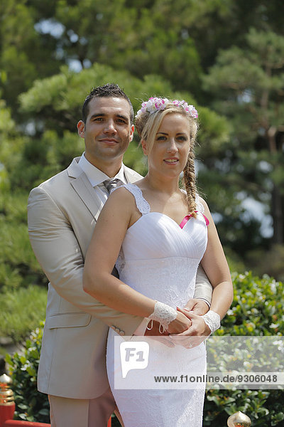 Braut und Bräutigam posieren in einem Park