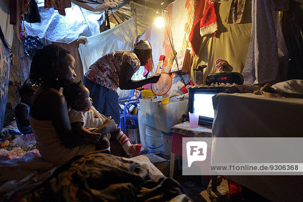 Woman and children in a ramshackle hut  Camp Icare  camp for earthquake refugees  Fort National  Port-au-Prince  Haiti