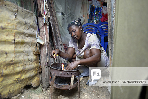 Frau kocht in improvisierter Küche in ärmlicher Hütte  Lager für Erdbebenflüchtlinge Camp Icare  Fort National  Port-au-Prince  Haiti