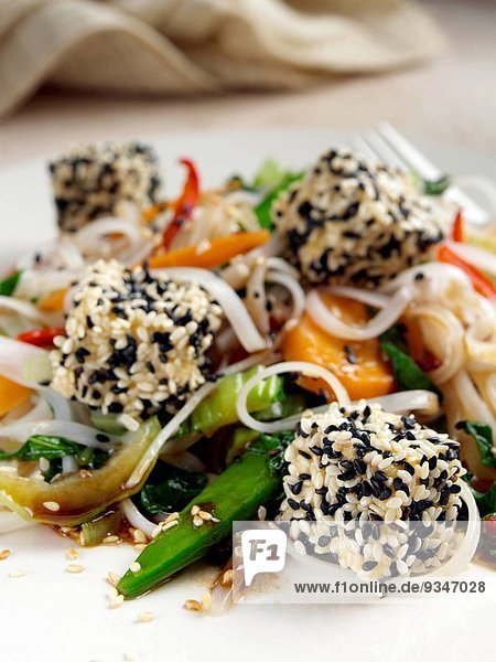 Deep Fried Tofu Coated In Black and White Sesame Seeds Rice Noodles Stir Fried Vegetables
