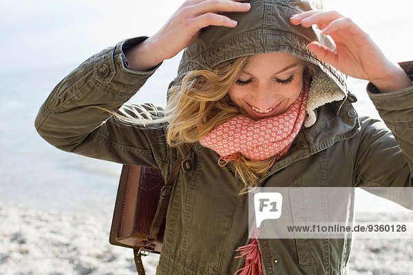 Woman all wrapped up on windy beach