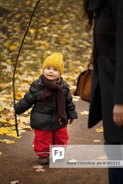 Junges Mädchen auf Spaziergang in Winterkleidung  Haltestange