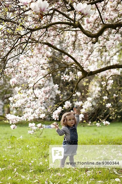 Junges Mädchen unter einem blühenden Baum stehend