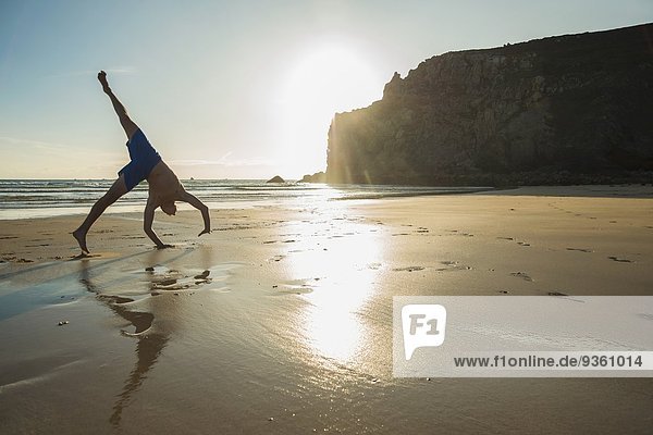Jugendlicher Junge beim Handstand am Strand  Camaret-sur-mer  Bretagne  Frankreich