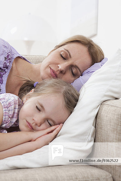 Germany  Munich  Mother and daughter (4-5) sleeping on sofa
