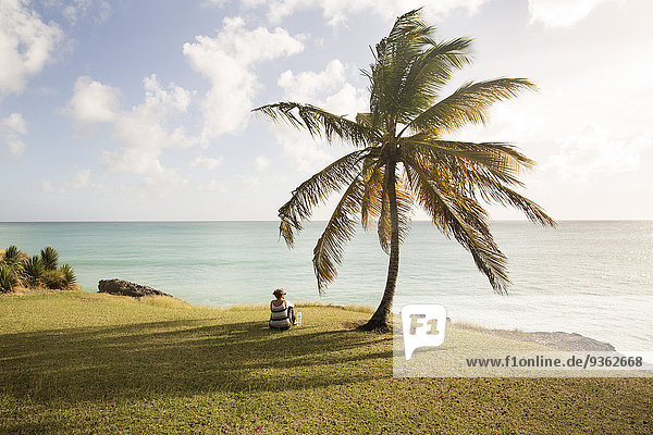 Karibik  Barbados  Frau an der Küste sitzend