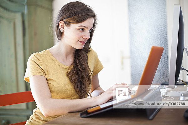 Young woman using her laptop at home