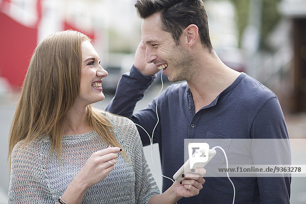 Young couple listening music with earphones