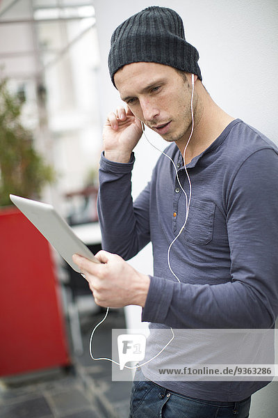 Porträt junger Musikhörer mit seinem digitalen Tablett