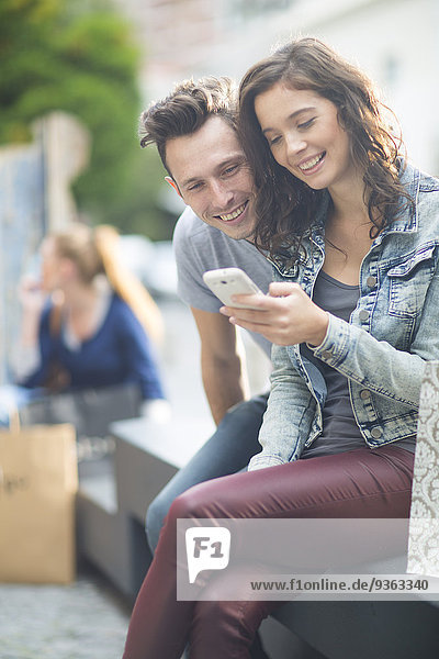 Portrait of young couple using smartphone