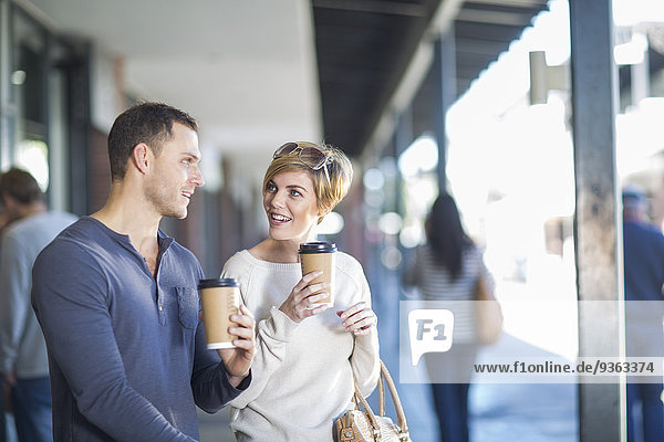 Smiling couple with coffees to go