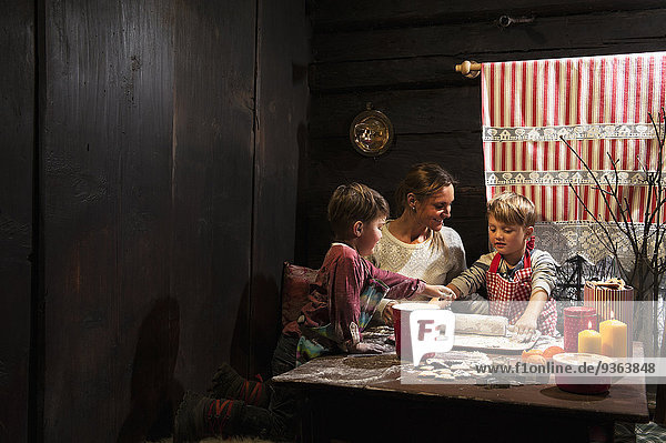 Mother and her two little sons baking Christmas cookies at Advent Season