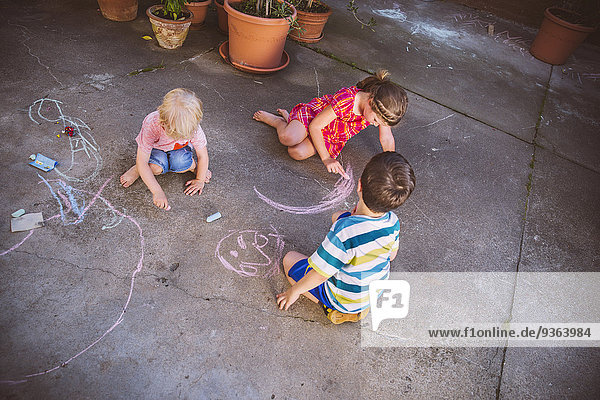 Deutschland  Nordrhein-Westfalen  Bornheim  Kinder spielen und zeichnen im Innenhof