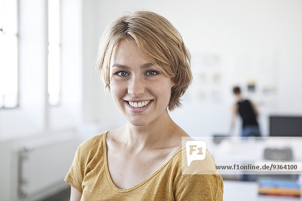 Portrait of smiling young woman in a creative office