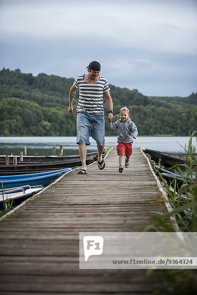 Deutschland  Rheinland-Pfalz  Laacher See  Vater läuft mit Sohn auf Steg