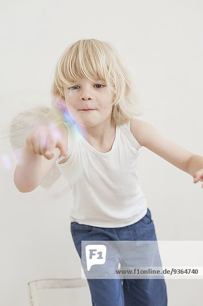 Portrait of smiling little boy watching a soap bubble