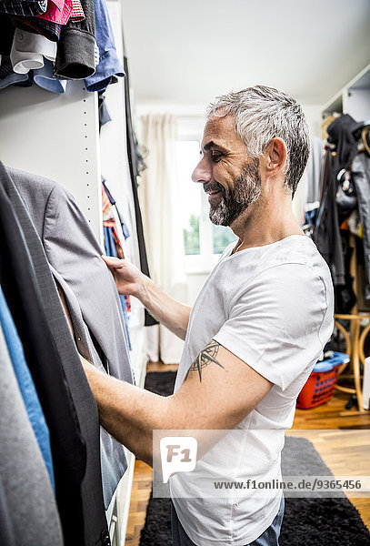 Man choosing clothes at his walk-in closet