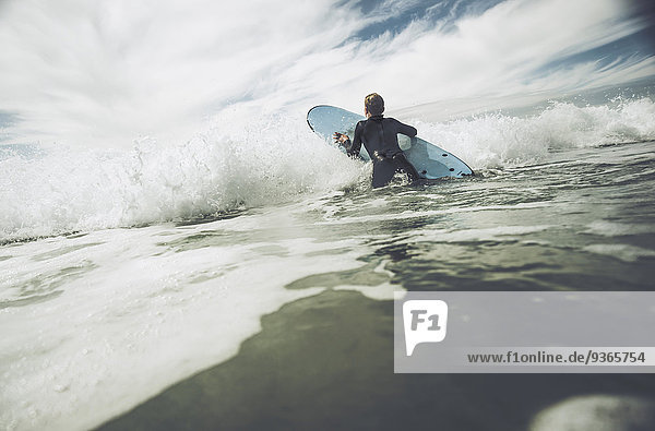 France  Bretagne  Camaret sur Mer  Teenage boy surfing at Atlantic coast