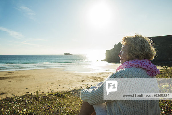 Frankreich  Bretagne  Camaret-sur-Mer  Seniorin an der Küste sitzend