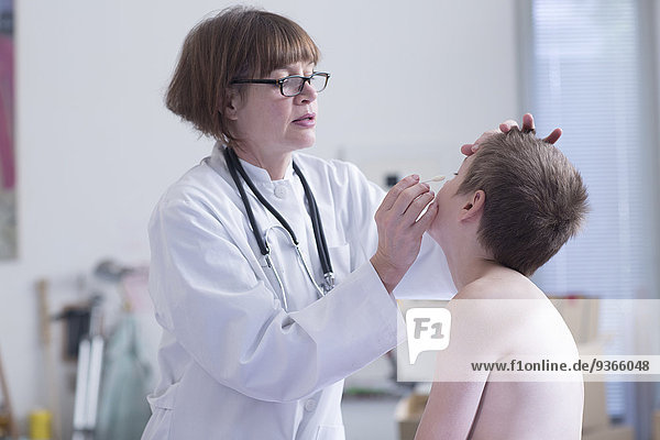 Arzt untersuchender Junge in der Arztpraxis