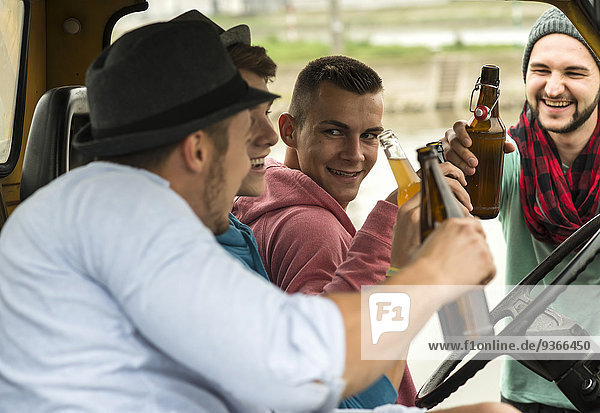 Group of friends drinking beer in car