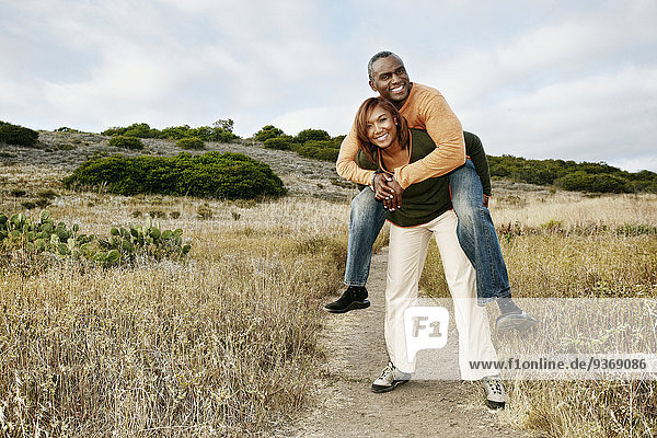 Black couple playing on rural path
