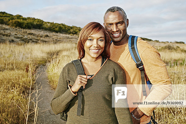 Black couple hiking on rural path