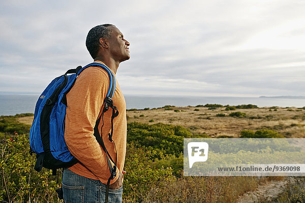 Black man overlooking rural hillside