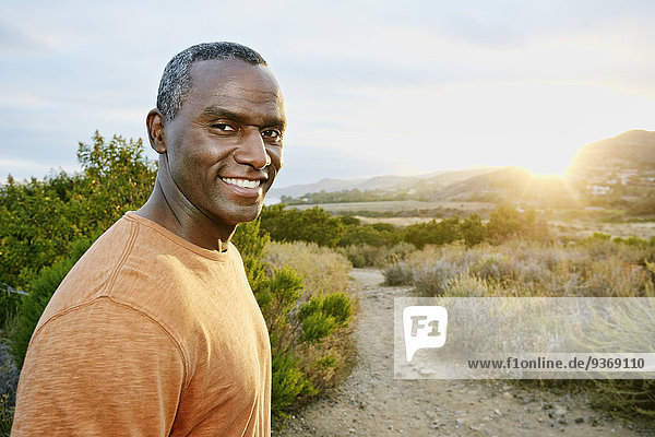 Black man smiling on rural hillside