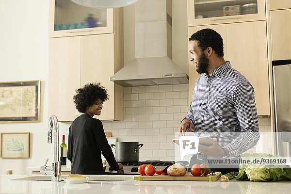Mixed race couple cooking together in kitchen