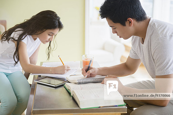 Hispanic brother and sister doing homework