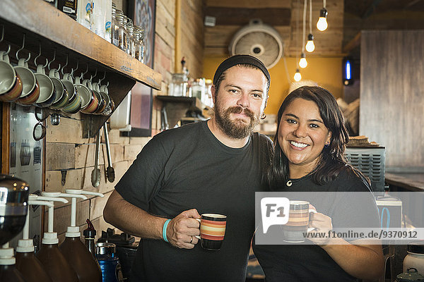 Hispanic couple working in coffee shop