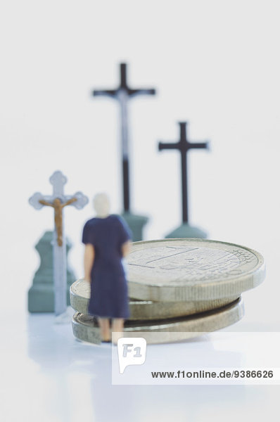 Kleine Figur und Geldmünzen auf einer Beerdigung