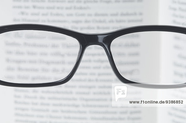 Brille und unscharfer Text in Buch