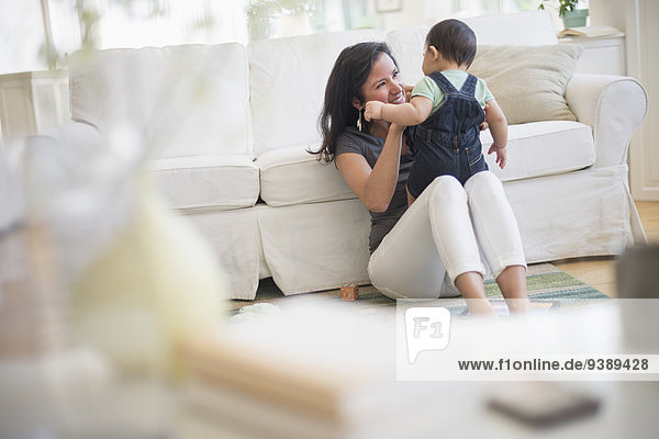 Mother playing with her son (6-11 months) in living room