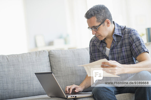 Man doing home finances with laptop