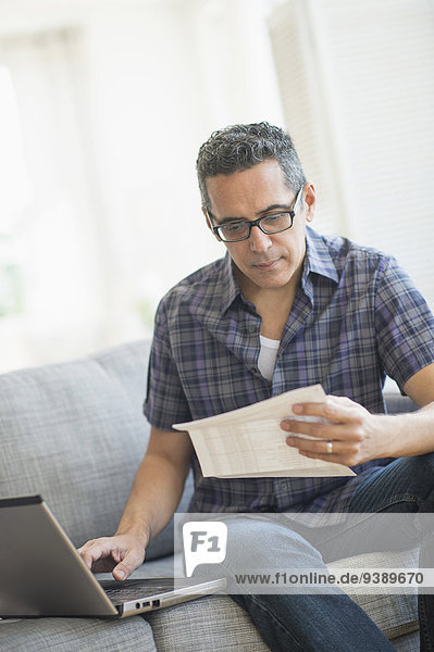 Man doing home finances with laptop