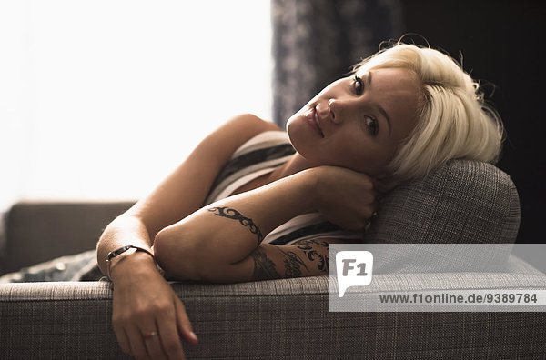Portrait of blonde woman relaxing on sofa