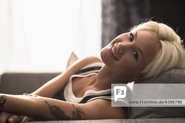 Portrait of blonde woman relaxing on sofa