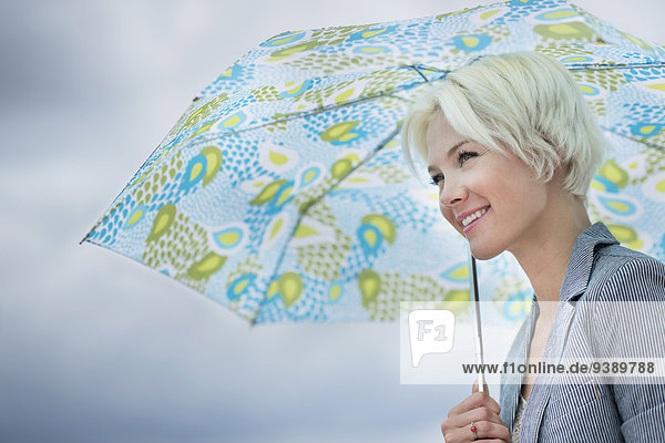 Blonde woman under umbrella