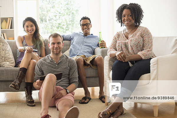 Portrait of group of friends sitting in living room