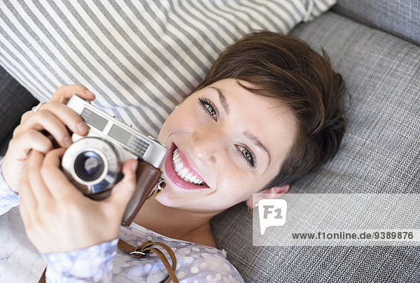 Portrait of young woman holding old fashioned camera