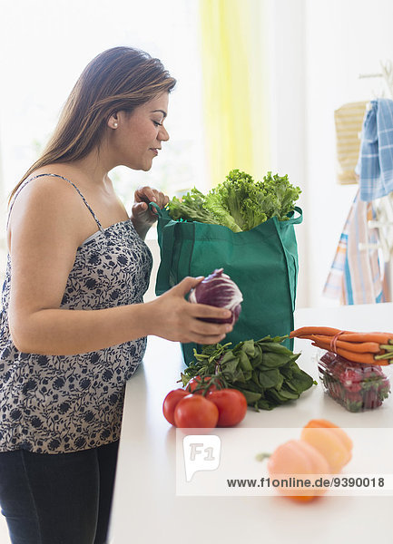 Frau Tasche Lebensmittelladen Gemüse herausnehmen
